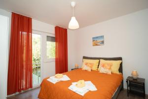 a bedroom with a orange bed with towels on it at Villa Paradise On The River in Blagaj