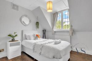 Una habitación blanca con una cama y una ventana en 4BR Cottage, Parking, NEC, Birmingham Airport, en Birmingham