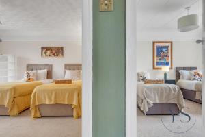 Un dormitorio con dos camas con sábanas amarillas. en 4BR Cottage, Parking, NEC, Birmingham Airport, en Birmingham 69 fotos más