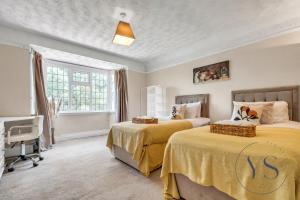 Un dormitorio con dos camas y una ventana en 4BR Cottage, Parking, NEC, Birmingham Airport, en Birmingham