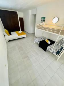 a room with two bunk beds and a tiled floor at Amazing Studio Flat Albufeira in Albufeira