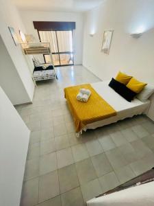 a bedroom with a bed with yellow and black pillows at Amazing Studio Flat Albufeira in Albufeira