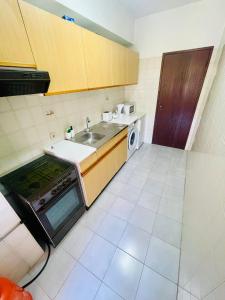 a small kitchen with a sink and a stove at Amazing Studio Flat Albufeira in Albufeira +10 photos