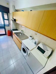 a kitchen with a washing machine and a sink at Amazing Studio Flat Albufeira in Albufeira
