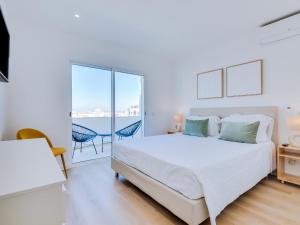 クアルテイラにあるAL Apartamento Alsolの白いベッドルーム(ベッド1台、バルコニー付)