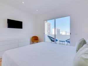 クアルテイラにあるAL Apartamento Alsolのベッドとテレビのある白い寝室