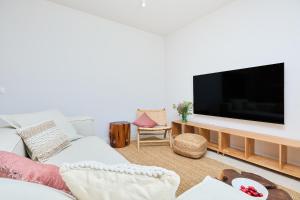 a living room with a white couch and a flat screen tv at Hedera Estate Villa Hedera XVIII in Mlini