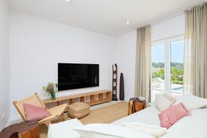 a living room with a couch and a tv at Hedera Estate Villa Hedera XVIII in Mlini