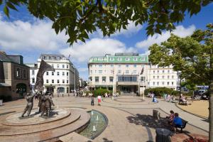 a city square with a statue in front of buildings at Pomme d'Or Hotel in Saint Helier Jersey