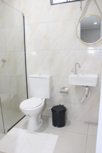 a bathroom with a toilet and a sink and a mirror at Liziane Souza da Silva in Catarina