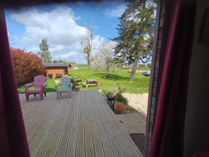 two chairs sitting on a deck with a yard at L'atelier mazé milon in Mazé