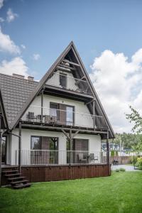 a large white house with a gambrel roof at Lawendowa Przystań in Wielen Zaobrzanski
