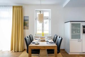 ein Esszimmer mit einem Holztisch und schwarzen Stühlen in der Unterkunft Ferienwohnung "Düne" im Ostsee-Domizil Sandburg in Kühlungsborn