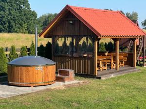 a gazebo with a hot tub and a grill at Przytulisko na Mazurach in Ruciane-Nida