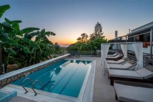 una piscina con sedie a sdraio e un resort di Homes Eva's garden -Your Secret Retreat with a Private Pool in Kos ad Asfendioú