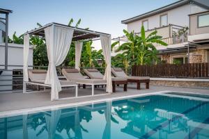 una piscina con sedie e un gazebo accanto a una casa di Homes Eva's garden -Your Secret Retreat with a Private Pool in Kos ad Asfendioú
