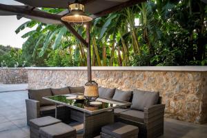 un patio con tavolo, sedie e alberi di Homes Eva's garden -Your Secret Retreat with a Private Pool in Kos ad Asfendioú