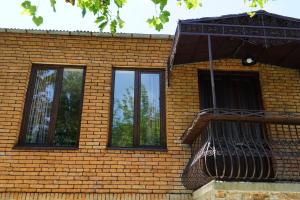 a brick building with three windows and a balcony at DRO Hotel in Kutaisi