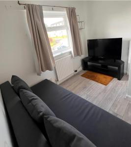 ein Wohnzimmer mit Couch und Flachbildfernseher in der Unterkunft NEW Spacious 6 Guests House Sheffield WIFI Parking in Ecclesfield