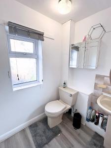 ein Badezimmer mit Toilette und Waschbecken und einem Fenster in der Unterkunft NEW Spacious 6 Guests House Sheffield WIFI Parking in Ecclesfield + 15 Fotos