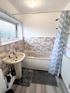 ein Badezimmer mit Badewanne und Waschbecken in der Unterkunft NEW Spacious 6 Guests House Sheffield WIFI Parking in Ecclesfield