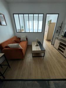 una sala de estar con un sofá y una mesa en Appart proche Paris Disney Bercy , Parking, en Joinville-le-Pont