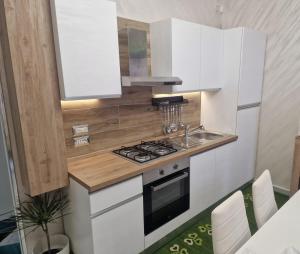 a small kitchen with white cabinets and a sink at Serenella House in Roccadaspide