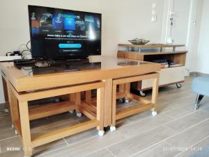 a tv on a wooden entertainment center with a tv on it at Havouli Cottage in Moúdhros