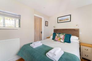 a small bedroom with a bed and a window at The Blue Duck in Hawkshead