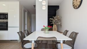 a white dining room with a white table and chairs at ASTER magic dúplex in Villajoyosa