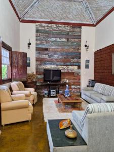 a living room with couches and a brick wall at Pousada Santa Bárbara in Tiradentes