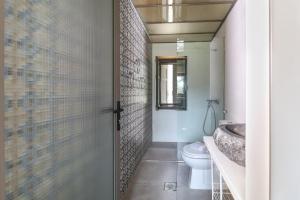 a bathroom with a toilet and a glass shower door at Just Barrett in Rovies