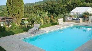 a swimming pool with two chairs and a couch at Piccozzo agritour in Casciana Terme