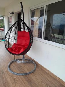 コダイカナルにあるScotberry Villaの部屋にある赤いクッション付きのブランコ椅子