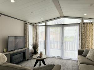 ein Wohnzimmer mit Sofa und Fernseher in der Unterkunft Stewarts Resort Lodge 41 in St Andrews