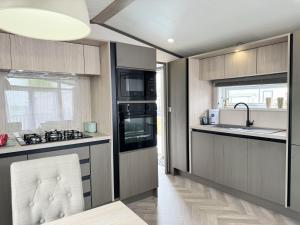 eine Küche mit Spüle und Herd oberen Backofen in der Unterkunft Stewarts Resort Lodge 41 in St Andrews