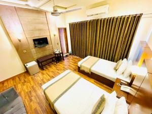 a hotel room with two beds and a couch at Shelton's Rezidor Hotel Gulberg Lahore in Lahore