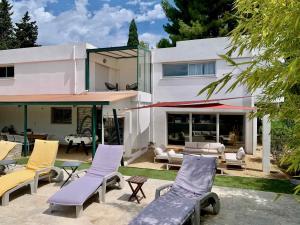 Casa blanca con sillas y patio en Villa Zen, en Pinet