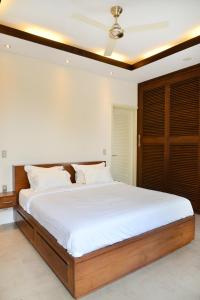 een slaapkamer met een groot bed met witte lakens bij Villa Tentrem Legian in Legian