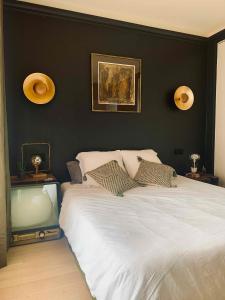 Un dormitorio con una cama blanca con una pared negra. en Villa Zen, en Pinet