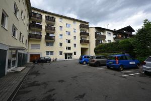 a parking lot with cars parked in front of a building at Ferienwohnung Am Rathaus in Garmisch-Partenkirchen
