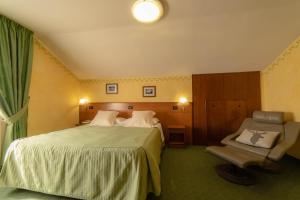 a hotel room with two beds and a chair at Hotel Beau Sejour Pré-Saint-Didier in Pré-Saint-Didier +69 photos