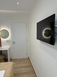 a flat screen tv hanging on a white wall at K & L Luxury Suite in Parga