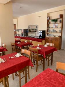 ein Restaurant mit roten Tischen und Stühlen und einer Theke in der Unterkunft Hotel Aurora in Vieste