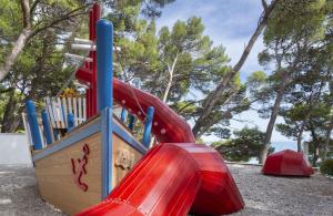 a playground with a red slide in a park at Bluesun Hotel Marina in Brela +28 photos