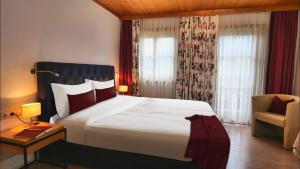 pokój hotelowy z dużym łóżkiem i krzesłem w obiekcie Landhaus Antonia w mieście Bruck an der Großglocknerstraße