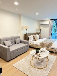 a living room with a couch and a bed and a table at 4Beds 4Baths New Renovated Entire House BTS Ekkamai in Bangkok