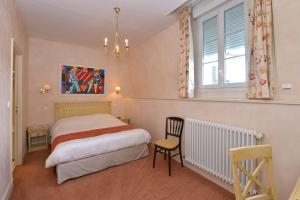 a bedroom with a bed and a chair and a window at Hôtel Castel Jeanson in Ay +47 photos