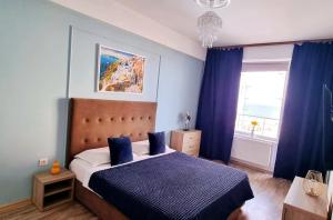 una camera da letto con un letto con lenzuola blu e una finestra di Mamaia a Mamaia