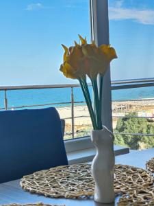 un vaso con un fiore su un tavolo vicino a una finestra di Mamaia a Mamaia